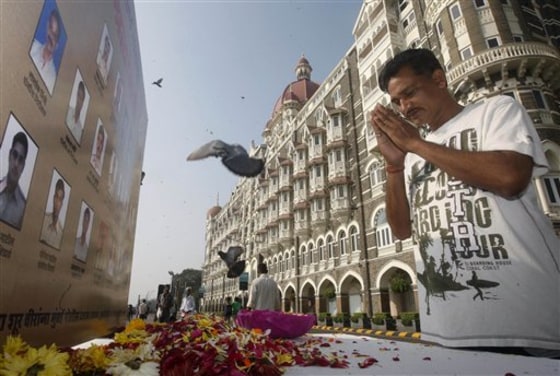 A man pays homage in front of portraits of police officers killed in the Mumbai terror attack. India rebuked Pakistan on Thursday for not punishing the alleged masterminds.